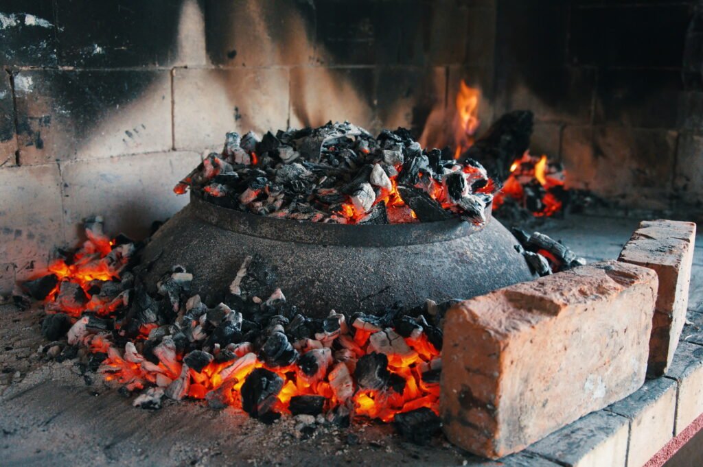 Grilled food in pan on open flame